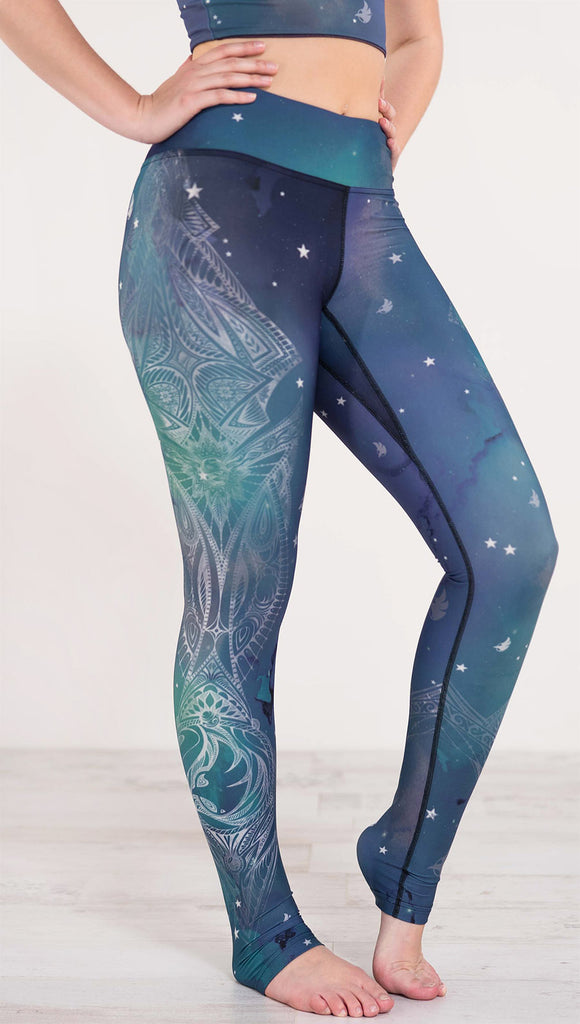 Right side of blue and green galaxy themed triathlon leggings with white henna inspired art running along the right side of the leg