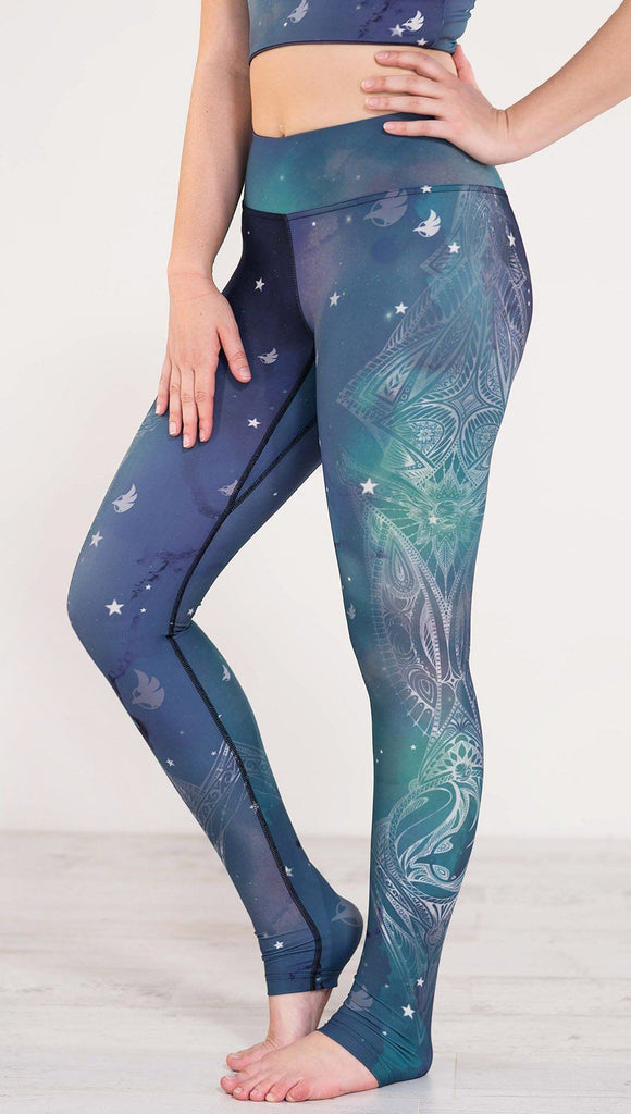 Left side view of blue and green galaxy themed triathlon leggings with white henna inspired art running along the left leg