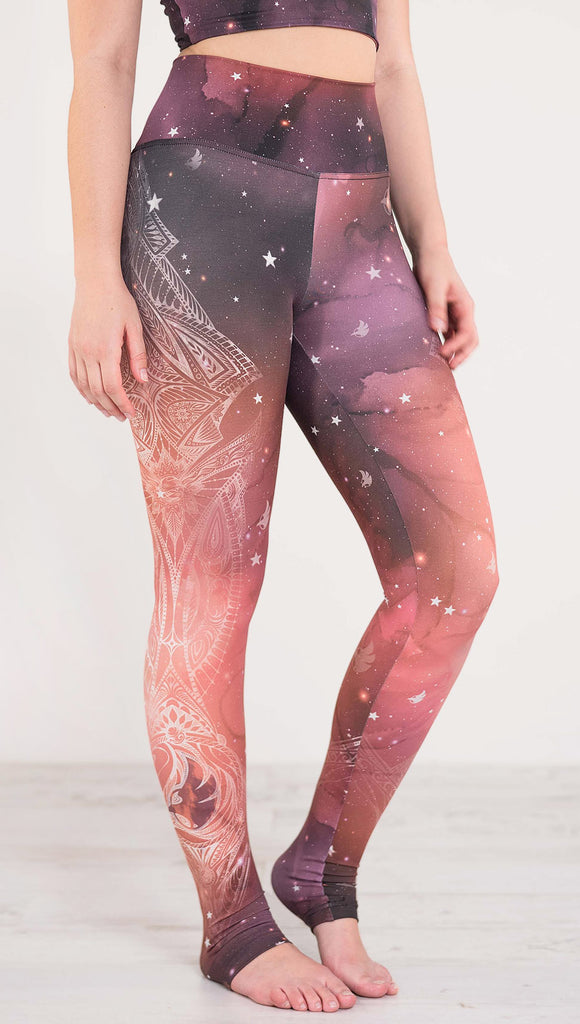 Right side view of model wearing a red, orange and purple galaxy themed athleisure leggings with white henna inspired art running along the right side of the leg