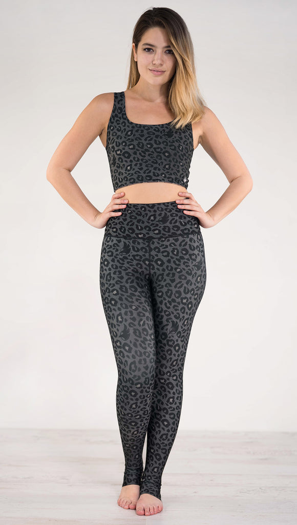 Front view of model wearing the reversible charcoal leopard print athleisure leggings in the colors gray and black