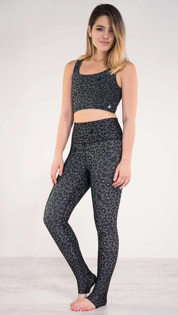 Left side view of model wearing the reversible charcoal leopard print athleisure leggings in the colors gray and black