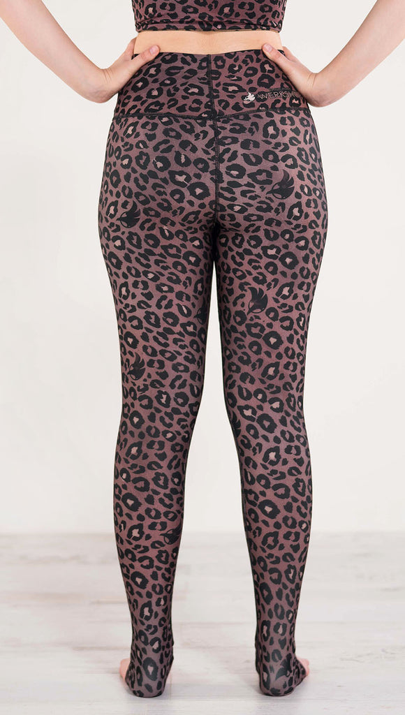 Back side view of model wearing the reversible red leopard print athleisure leggings in the colors dusty red and black