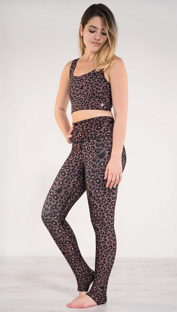 Left side view of the model wearing the reversible red leopard print athleisure leggings in the colors dusty red and black