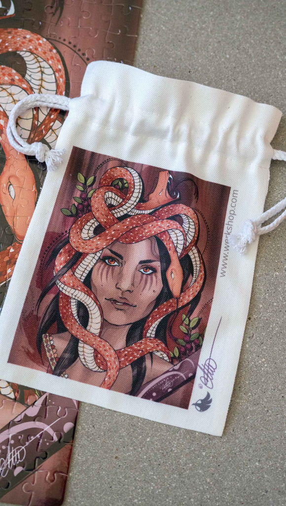 WERKSHOP Medusa canvas drawcord pouch (comes free with matching puzzle)! The artwork features medusa with her crown of snakes over a mauve background with berries and pops of green leaves.