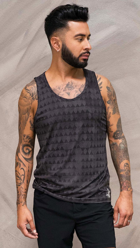 Close up front view of model wearing charcoal black printed tank top with distressed tribal inspired art