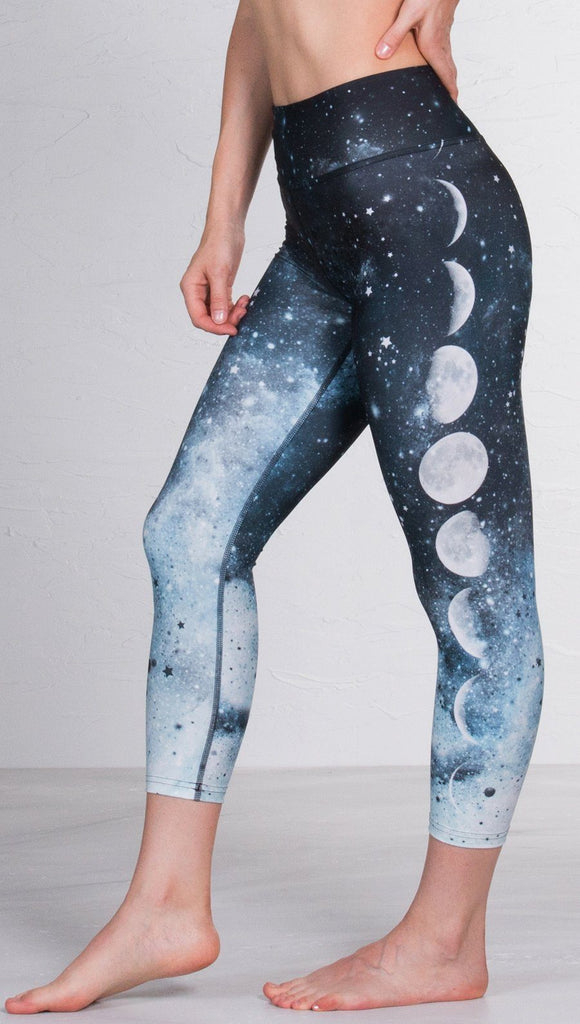 closeup left side view of model wearing moon cycle design printed capri leggings