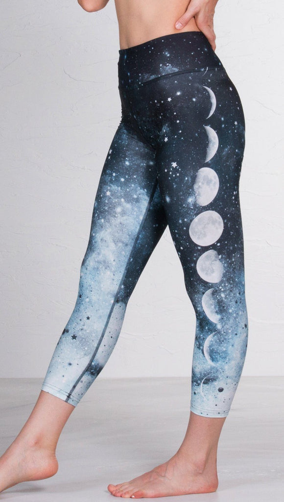 closeup left side view of model wearing moon cycle design printed capri leggings