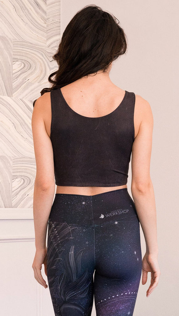 closeup back view of model wearing reversible tank top with dark purple galaxy night sky on one side and textured black reverse side