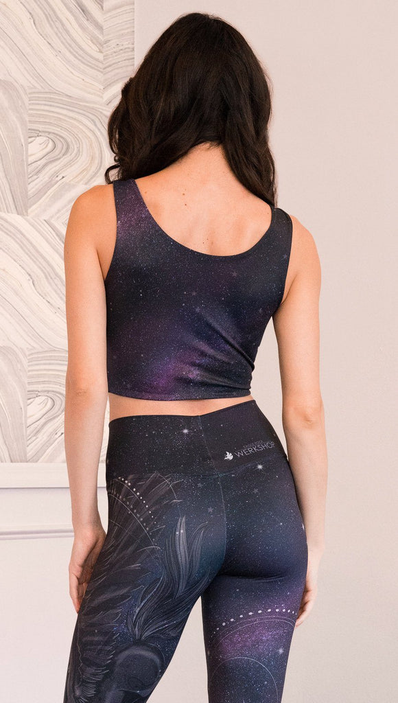 closeup back view of model wearing reversible tank top with dark purple galaxy night sky on one side and textured black reverse side