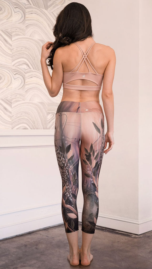 back view of model wearing owl themed capri leggings