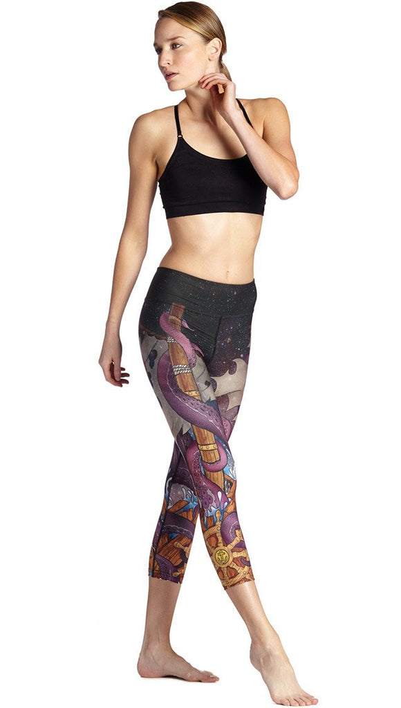 right side view of model wearing mythical octopus themed printed capri leggings