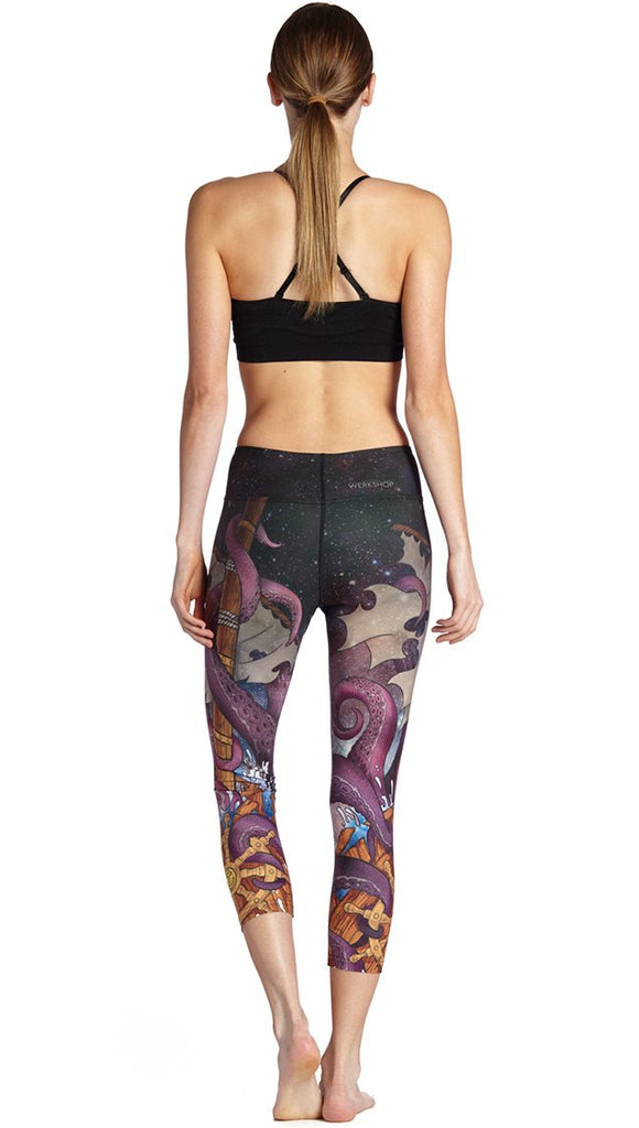 back view of model wearing mythical octopus themed printed capri leggings