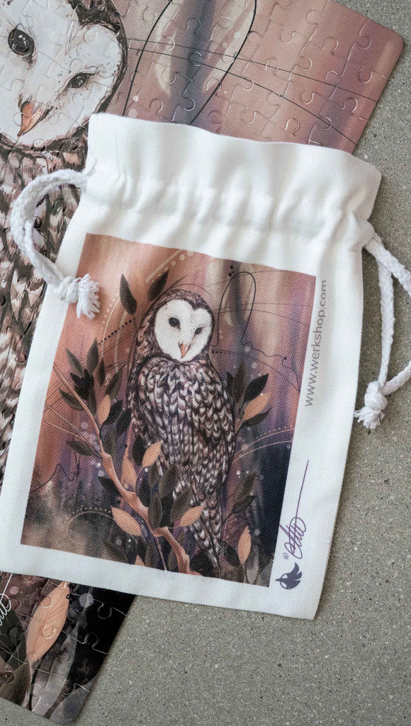 Canvas dawstring pouch featuring WERKSHOP Barn Owl Artwork ~ comes free with matching puzzle.. The puzzle is printed with original artwork of an Owl by Chriztina Marie. It features a barn owl perched on top of a branch with whimsical leaves. The overall color story is of mauves, warm browns and complimentary green leaves.