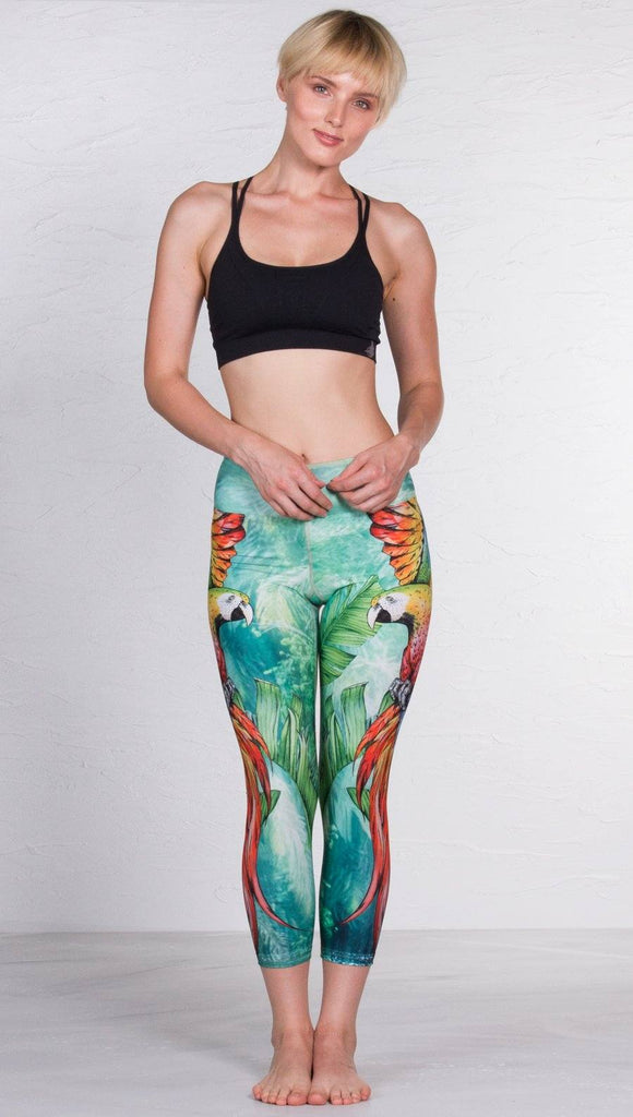  front view of model wearing macaw themed capri leggings