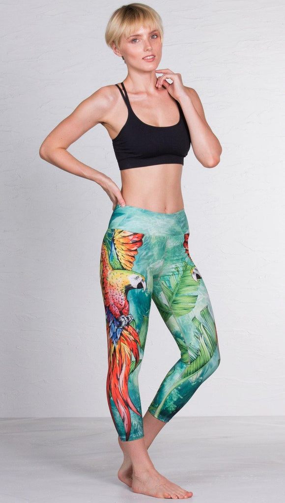 front view of model wearing macaw themed capri leggings