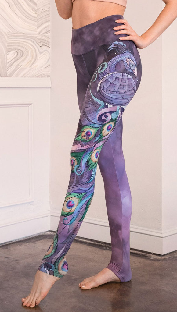 closeup left side view of model wearing peacock themed full length leggings
