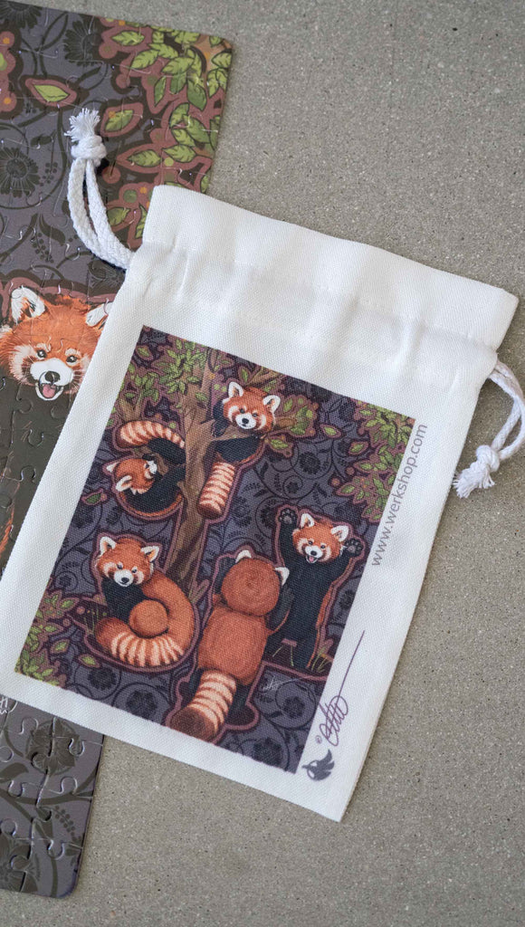WERKSHOP Red Pandas Canvas drawstring pouch (comes free with matching puzzle)!. The artwork features 5 adorable red pandas playing near an abstract tree with a warm gray background.
