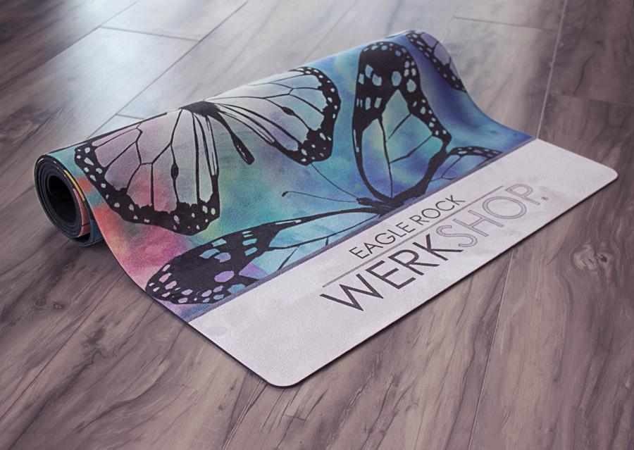 closeup view of partially rolled colorful butterfly themed printed yoga mat