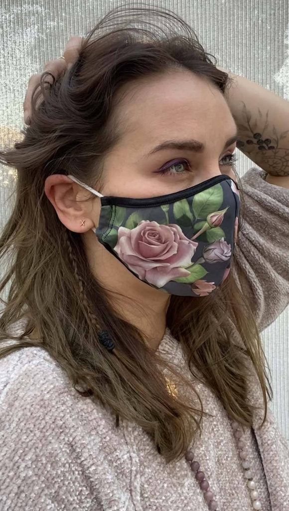 Right side view of model wearing a grey mask with pink roses and green leaves