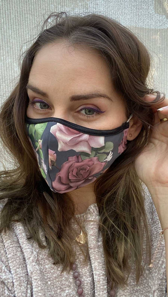 Slightly turned left side view of model wearing a grey mask with pink roses and green leaves and the WERKSHOP logo on the bottom corner in white