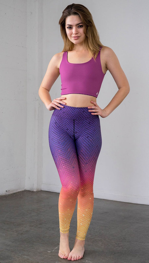 Full length front view of a model wearing purple/pink/yellow ombre mosaic tile print full length leggings