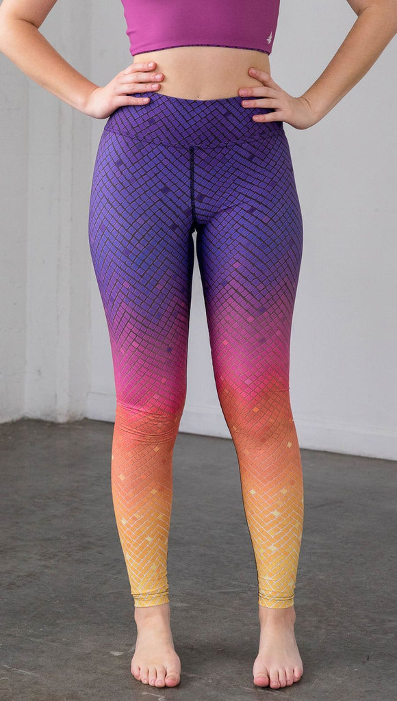 close up front view of a model wearing purple/pink/yellow ombre mosaic tile print full length leggings