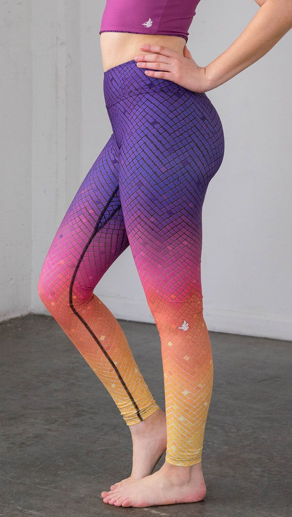 close up side view of a model wearing purple/pink/yellow ombre mosaic tile print full length leggings