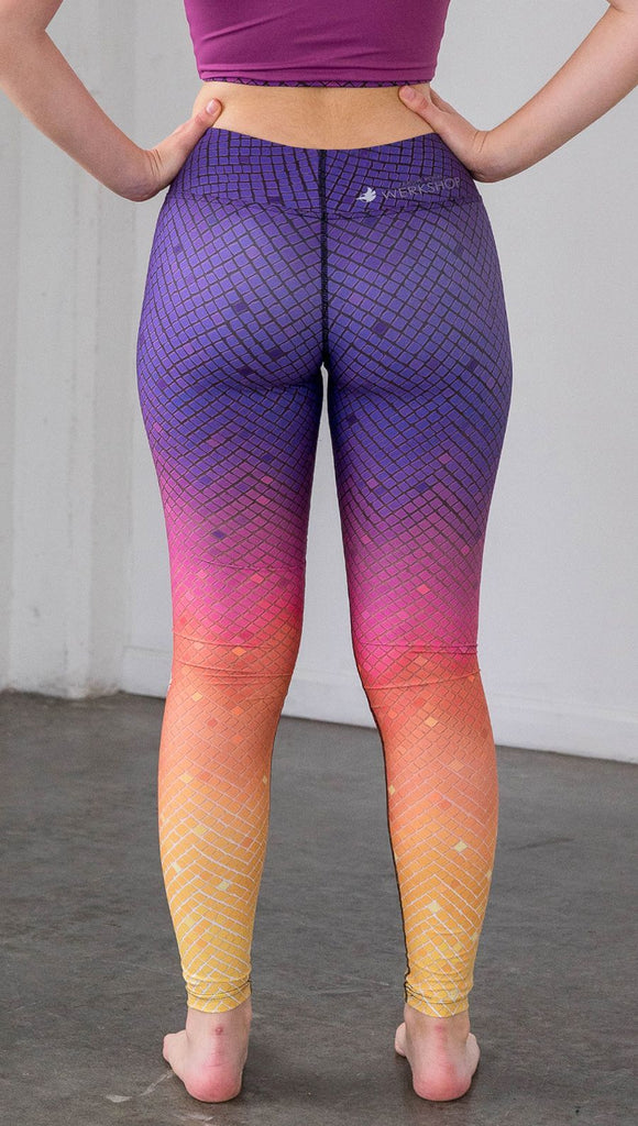 close up rear view of a model wearing purple/pink/yellow ombre mosaic tile print full length leggings