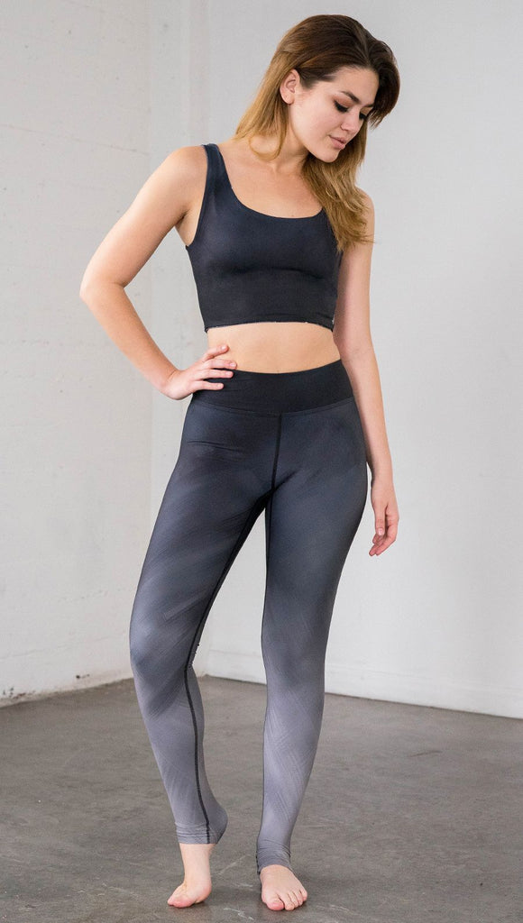 Full length front view of model wearing full length black to gray ombre leggings with rose details and a matching crop top