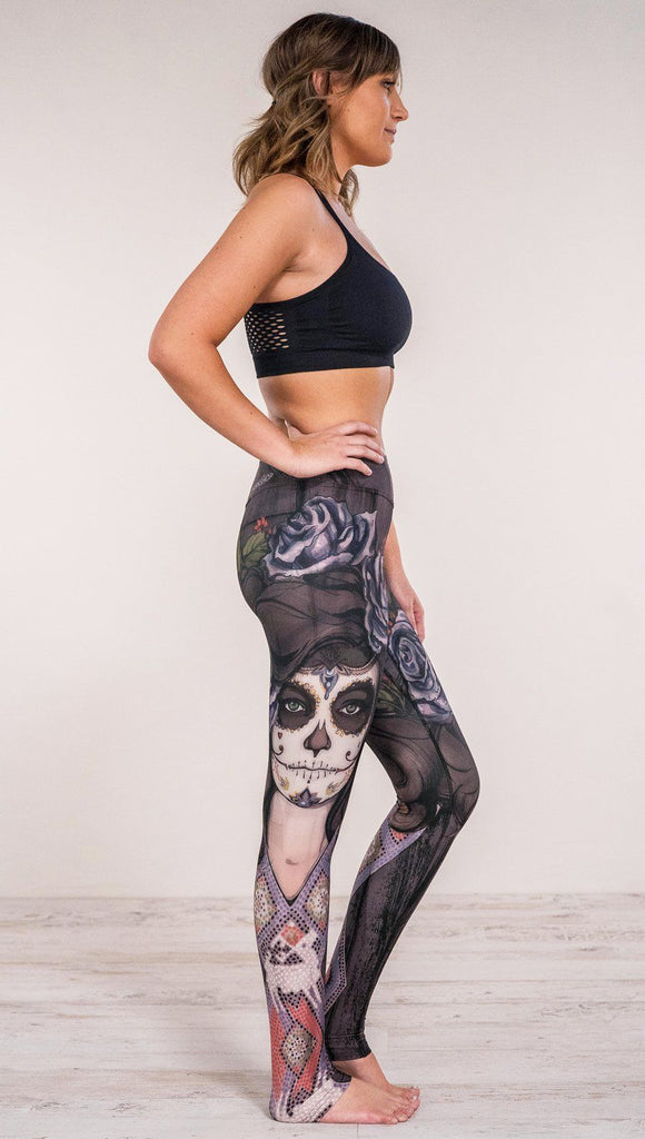 Right side view of model wearing sugar skull themed printed full length leggings