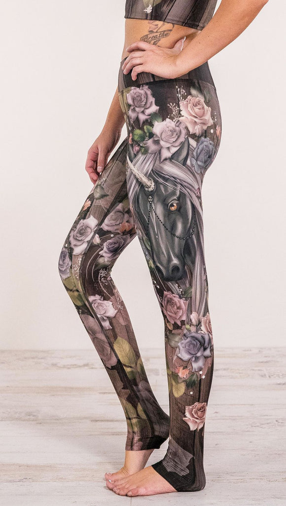 Close up side view of model wearing unicorn and rose printed full length leggings