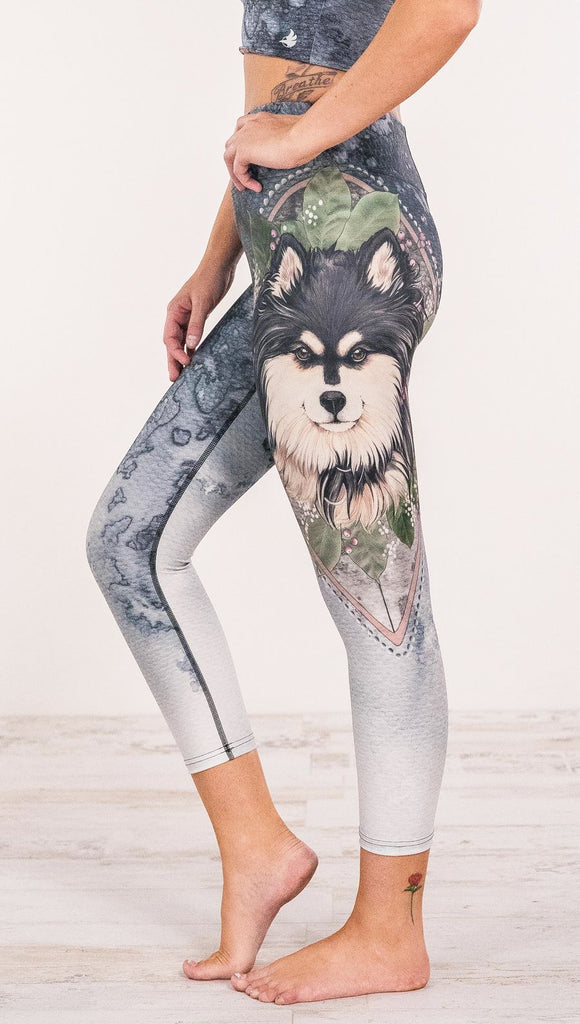 Close up side view of model wearing Finnish Lapphund artwork themed leggings