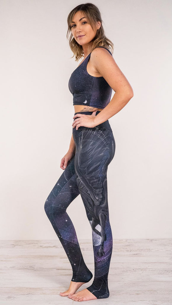 Side view of model wearing fantasy flying pegasus themed printed full length leggings