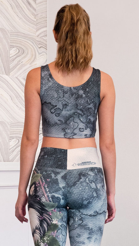 back view of model wearing watercolor artwork themed reversible sports top