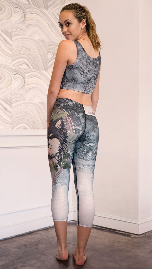 back view of model wearing capri Finnish Lapphund artwork themed leggings