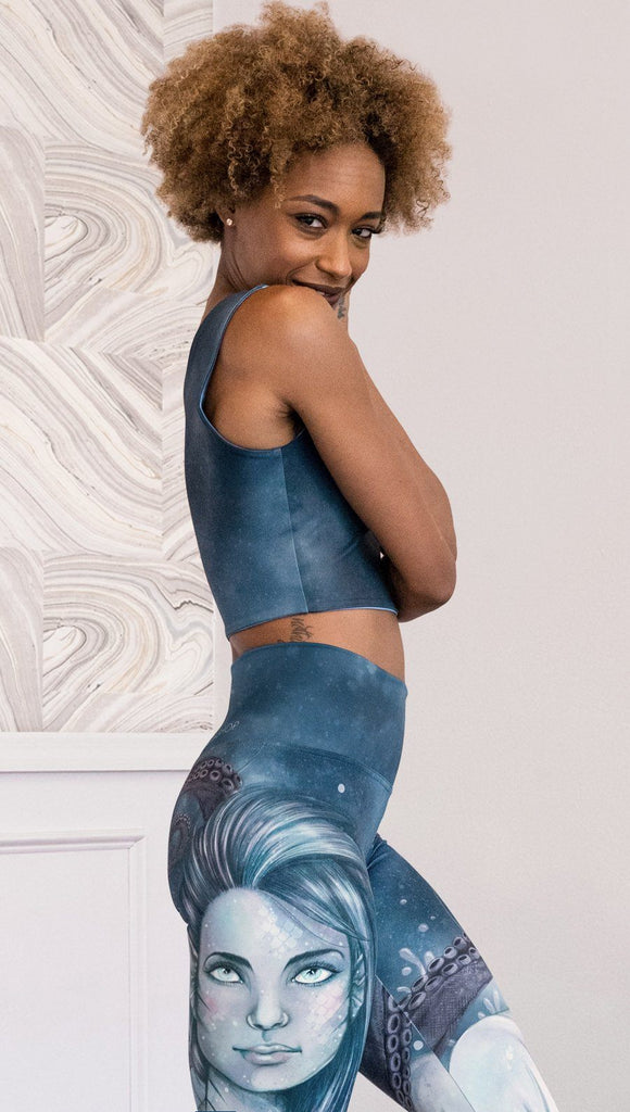 Right side view of model wearing reversible tank top with ethereal dark blue water print on one side and textured watercolor print on the reverse side