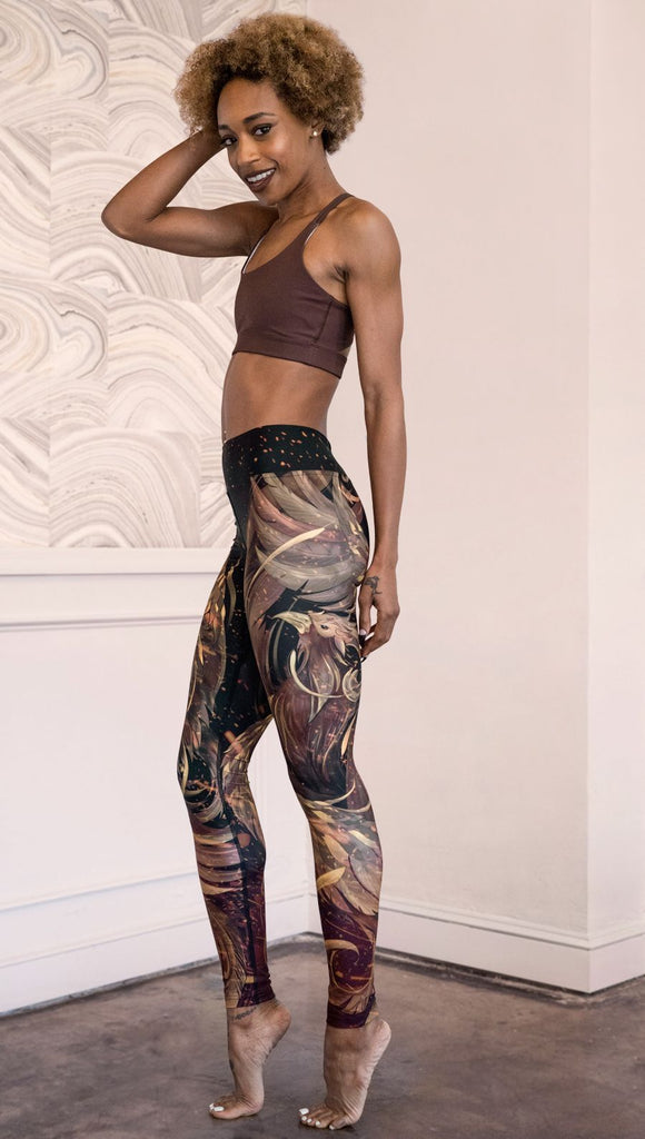 left side view of model wearing phoenix themed full length leggings