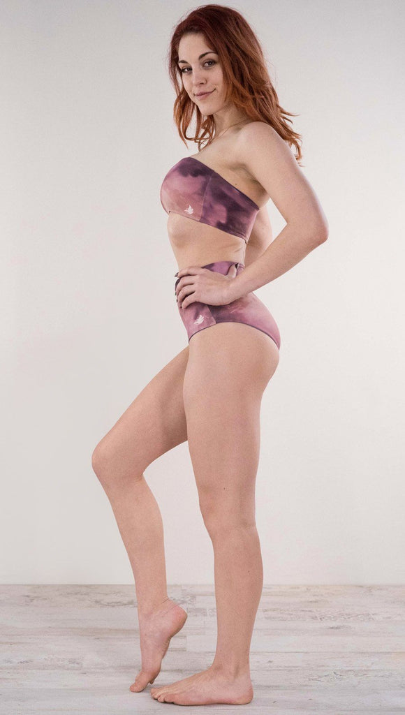 Left side view of model wearing the reversible Peacock high waist bikini bottom in the Rose Quartz side in the colors pink and purple