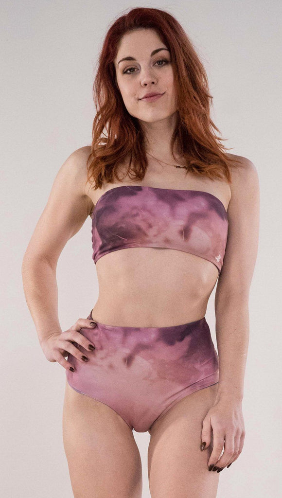 Front view of model wearing the reversible Peacock high waist bikini bottom in the Rose Quartz side in the colors pink and purple