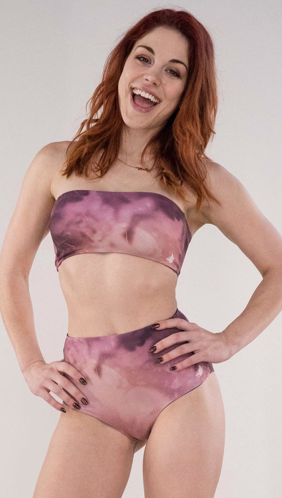 Front view of model wearing the reversible Peacock high waist bikini bottom in the Rose Quartz side in the colors pink and purple