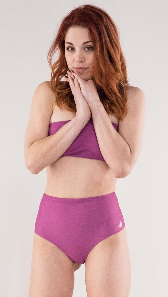 Front view of model wearing the reversible Rainbow Mosaic high waist bikini bottom in the reversed fuchsia side 