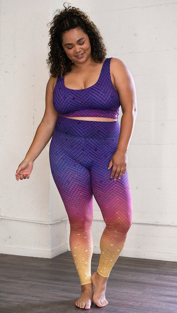Front view of a model wearing purple/pink/yellow ombre mosaic tile print full length leggings
