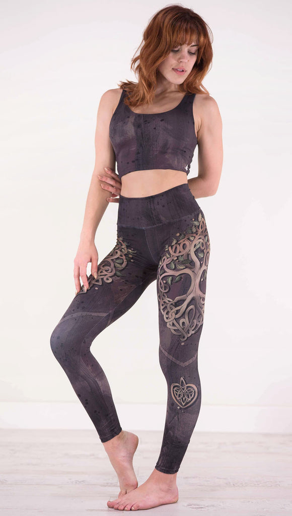 Front view of model wearing the Tree of Life athleisure leggings in a brown wood grain print with a tree on each side