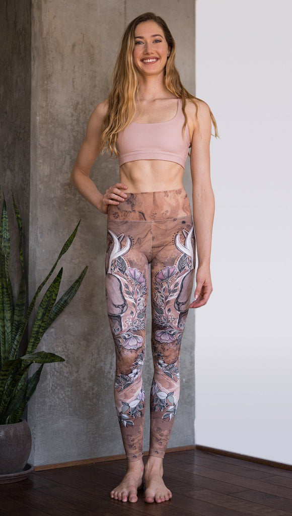front view of model wearing full length leggings with printed jackalope design