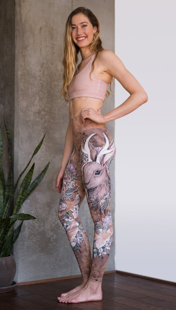 left side view of model wearing full length leggings with printed jackalope design