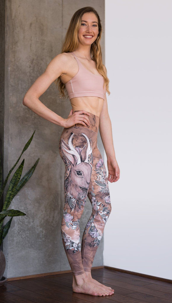 right side view of model wearing full length leggings with printed jackalope design