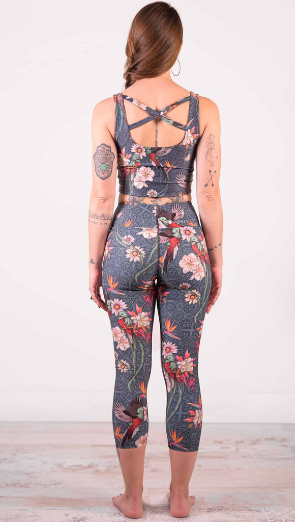 Model wearing WERKSHOP Quetzal Triathlon Capri Leggings. The leggings are printed with with original quetzal artwork with clusters of tropical flowers and birds of paradise.