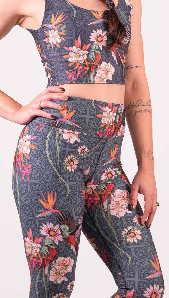 Model wearing WERKSHOP Quetzal Triathlon Capri Leggings. The leggings are printed with with original quetzal artwork with clusters of tropical flowers and birds of paradise.