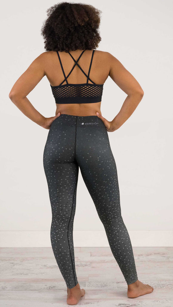 full body back view of model wearing WERKSHOP Black Ombre Full Length Triathlon Leggings. The artwork is dark charcoal on top and fades to a lighter gray on the bottom - with a lot of texture from bead-like artwork.