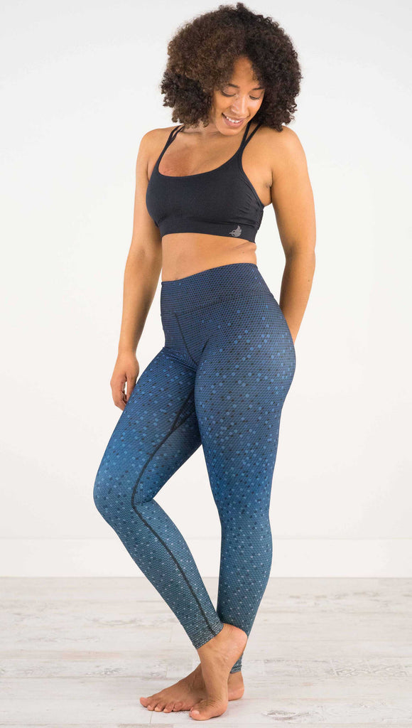 Full body side view of model wearing WERKSHOP Black Ombre Full Length Triathlon Leggings. The artwork is dark indigo blue on top and fades to a lighter blue on the bottom - with a lot of texture from bead-like artwork.